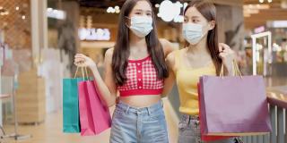 新常态购物，亚洲女性购物在服装商店与面膜。
