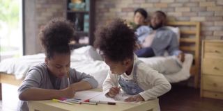 两个非洲女儿正在为她的父亲和母亲写和画贺卡