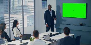 多元化办公室会议室会议:成功的黑人男性项目经理使用绿屏色度键墙电视向投资者展示产品。电子商务战略。广泛的静态照片