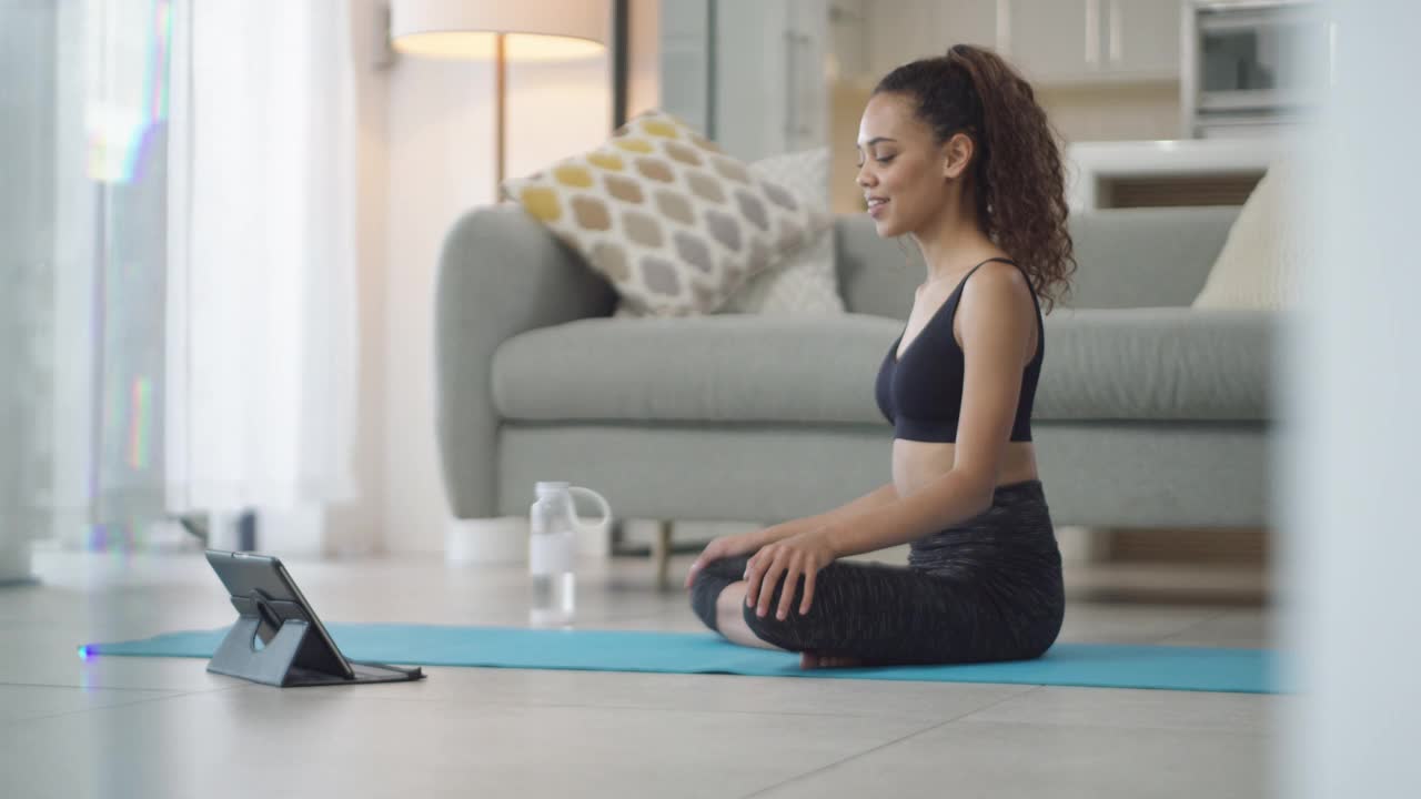 一名年轻女子在家练瑜伽时使用电子平板电脑的4k视频片段