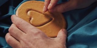 男人的手把糖饼干画成心形。