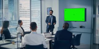 办公室会议室会议介绍:积极的白人商人谈话，使用绿色屏幕彩色键墙电视。成功向多民族投资者展示产品