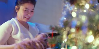 幸福的圣诞假期与亚洲女性休闲毛衣坐放松阅读小说书与小哈巴狗坐在一起，快乐的在客厅家里圣诞节的想法