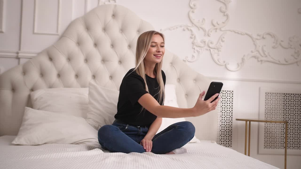 好玩的女士记录自己或在卧室里用手机拍照。