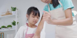 亚洲孩子在家里一起烤饼干前测量黄油，生活方式的概念。