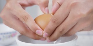 孩子的手在烘烤前敲鸡蛋。