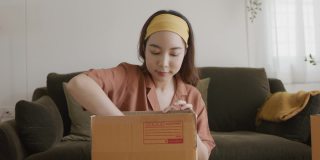 亚洲女人的主人包装纸板箱得到邮包。