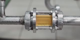 靠近一根带有玻璃碎片的钢管，用于啤酒质量控制。视频。现代啤酒厂的精酿啤酒生产