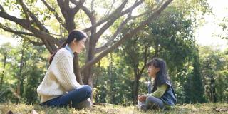 年轻的亚洲母亲正在和学龄前的女儿交谈