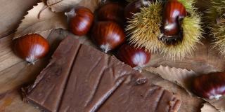栗子蛋糕的特写，新鲜采摘的栗子，刺猬和栗子叶。十月，板栗收获季节。带有新鲜秋天水果的典型甜点。