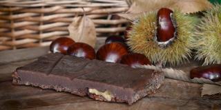 栗子蛋糕的特写，新鲜采摘的栗子，刺猬和栗子叶。十月，板栗收获季节。带有新鲜秋天水果的典型甜点。