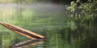 古老的木桨在清澈的湖水上划动。手持视频