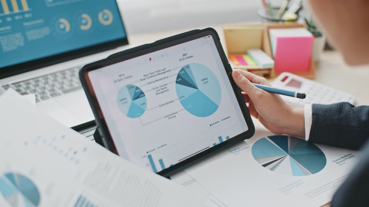 特写女商人使用数字平板电脑分析商业数据财务分析师在数字平板电脑上看到图表和图表