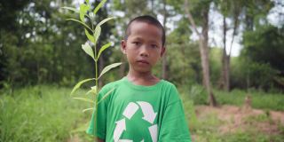 孩子在森林里为种植园搬运树木。地球日。