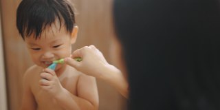 可爱的男孩在学自己刷牙。