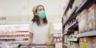 亚洲妇女戴防护口罩和购物。