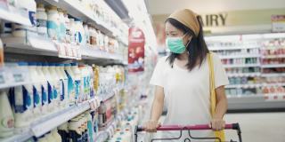 一位女士在超市里戴着防护口罩。