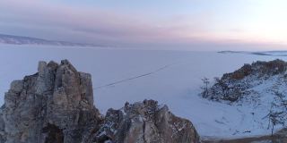 空中轨道拍摄的日落Olkhon岛上的沙曼卡岩石。冬天的风景。受欢迎的旅游目的地。自然地标。全景