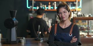 4K亚洲女咖啡厅老板的肖像，双手交叉站在吧台前