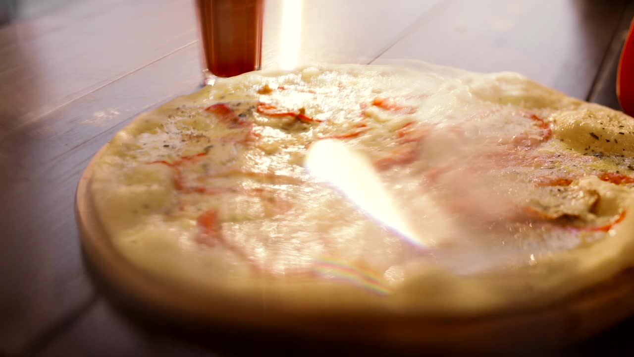 意大利披萨与切片蔬菜，融化的奶酪在前景。把奶酪放在烤披萨上的人。木制盘子上的典型意大利菜。开胃的披萨。Delisious菜