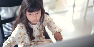 小女孩在家里的台式电脑上在线学习