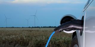风车在麦田里产生能量供电动汽车充电