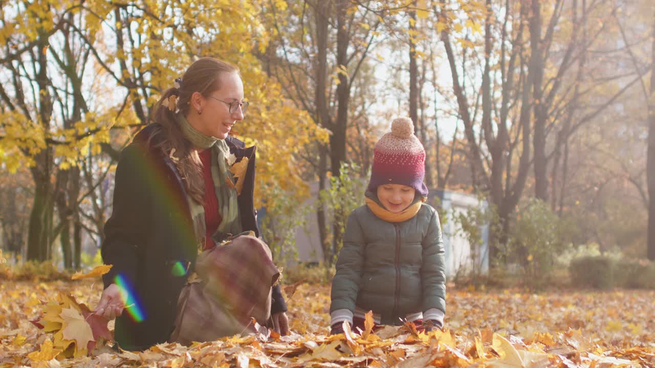 一个阳光明媚的秋日，一家人在公园里扔树叶