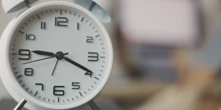 时间流逝的时钟快速移动在早上的工作高峰时间，商业妇女工作在电脑和她的办公桌在家里显示出与时间竞争的压力忙碌工作的概念。