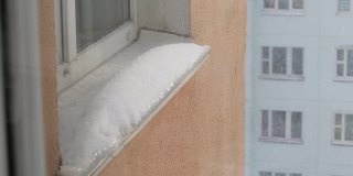 冬天，雪花落在窗台上。窗台上的雪帽，外面