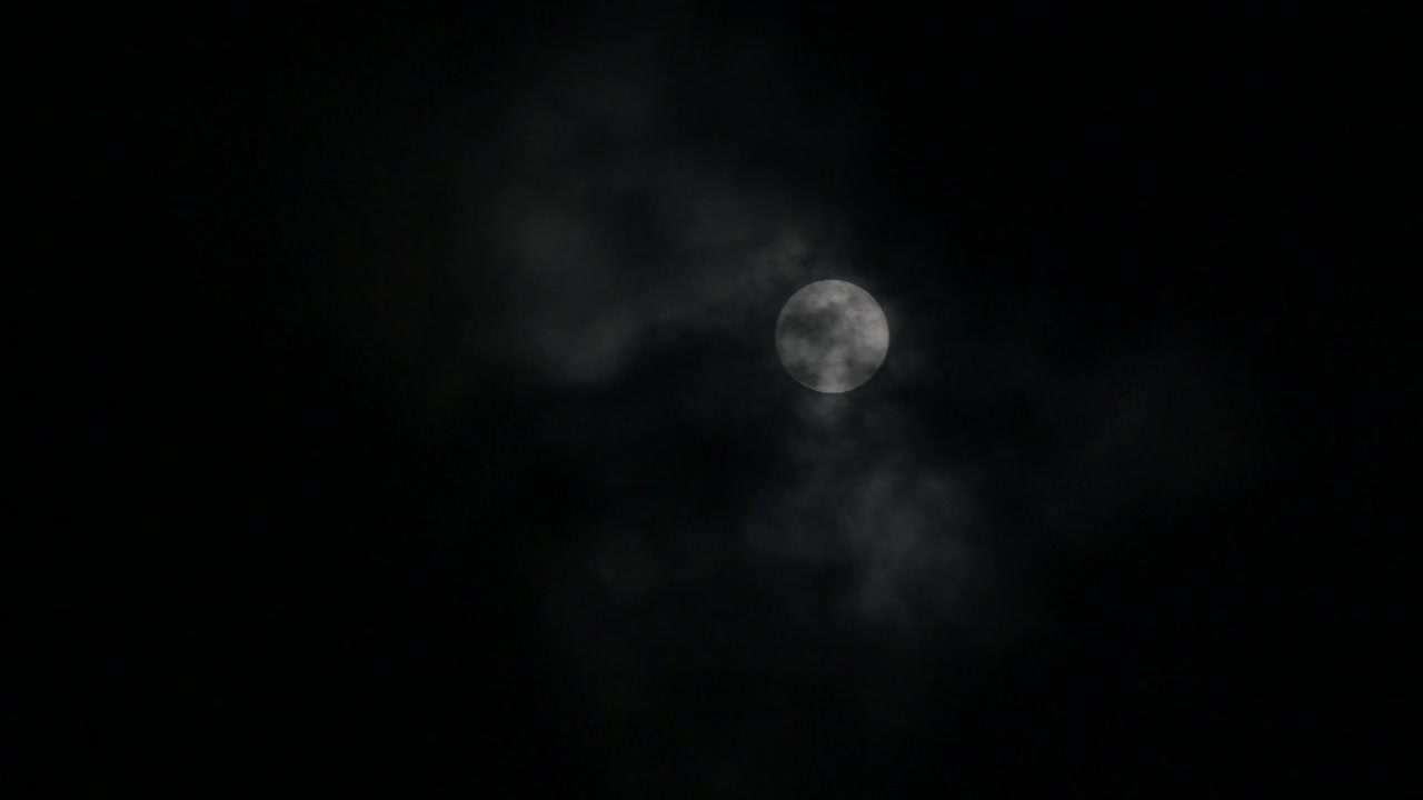 云层在满月中移动，大气看起来神秘而可怕。4 k的视频。