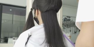 年轻的亚洲美女正在理发店理发。