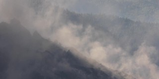 火山烟雾从燃烧的山坡上下降