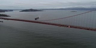 加利福尼亚州旧金山的金门大桥。多云的天空。恶魔岛和监狱，背景中的集装箱船。美国
