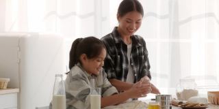 亚洲母亲和女儿在室内用面粉烘焙