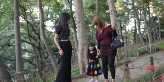 母亲和两个孩子在公园里抚摸红蜘蛛百合