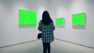 一个年轻的女人在画廊里看绿色的镜框视频素材模板下载