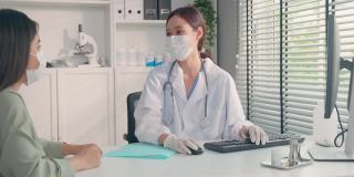亚洲专科女医生给小女孩病人讲解诊断。专业女医生佩戴口罩，使用笔记本电脑，及时向住院病人提供治疗方案。