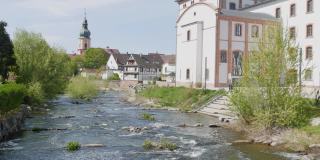 在风景如画的德国教堂中，可以看到山的堤岸、湍急的小溪和威尔斯特村