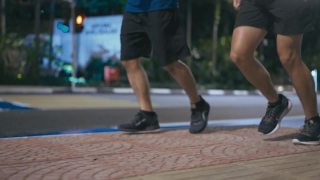近距离低角度亚洲华人活跃的老人和他的儿子在晚上下班后一起在城市跑步慢跑视频素材模板下载