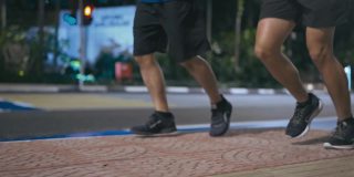 近距离低角度亚洲华人活跃的老人和他的儿子在晚上下班后一起在城市跑步慢跑