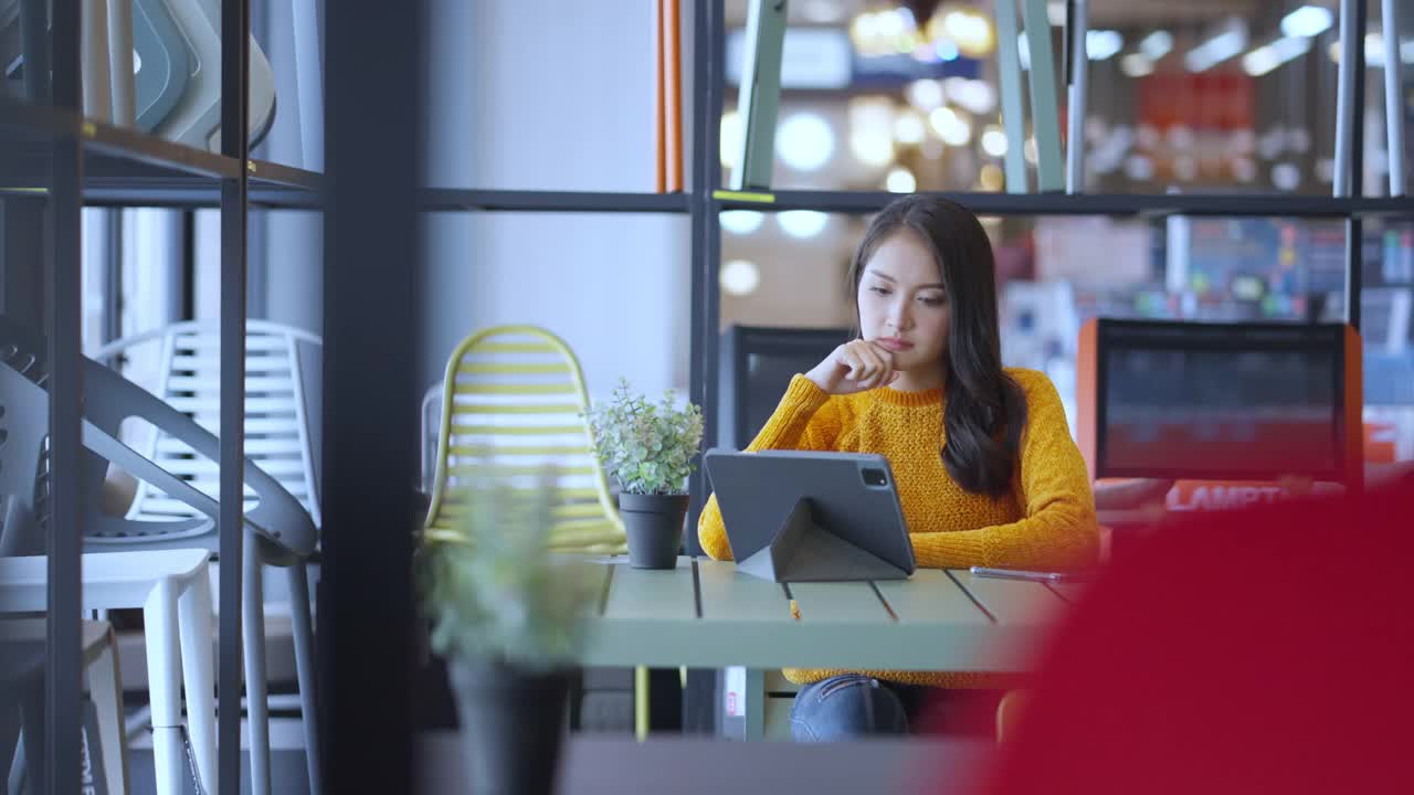 聪明休闲的亚洲女商人创业公司企业家小企业主工作和讨论与客户在新商店商店办公室背景迷人开朗的女性使用平板智能手机