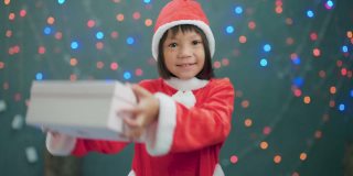 女孩穿着圣诞老人的衣服打开礼品盒。