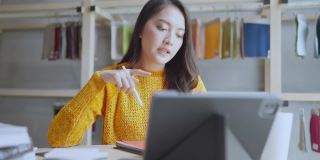 亚洲女性创意设计师项目讨论和演示与客户视频在线会议使用平板电脑技术设备与样品的材料和项目选项的选择，商业概念