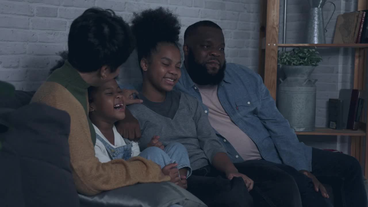 非裔美国家庭在家里一起看电视