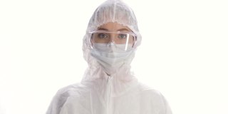 白色背景上穿着防护服、面具、手套和眼镜的女人的肖像。冠状病毒大流行隔离。COVID-19流行病。怕感染