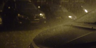 汽车在房子的院子里停成一排。雨下得很大，有闪电