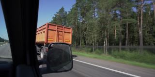 在高速公路上，小型货车超过带拖车的卡车