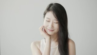黑色长发的韩国美女在白色摄影棚里拍照。风吹过她的头发。慢动作视频视频素材模板下载