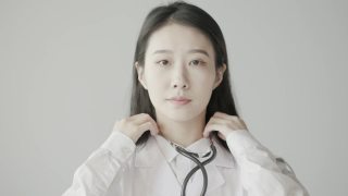年轻美丽的亚洲女医生，带着自信的微笑看着镜头，一个成功的医生形象视频素材模板下载
