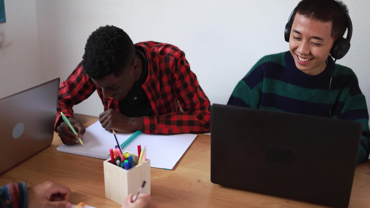 多种族学生在一起学习的同时阅读书籍和使用笔记本电脑-学校的概念